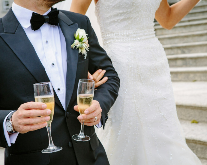 man holding two champagne flutes near woman