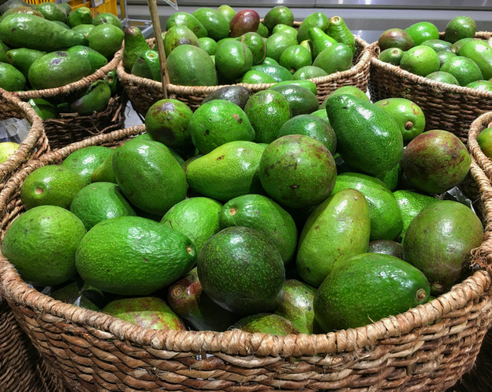 green fruits on brown woven basket