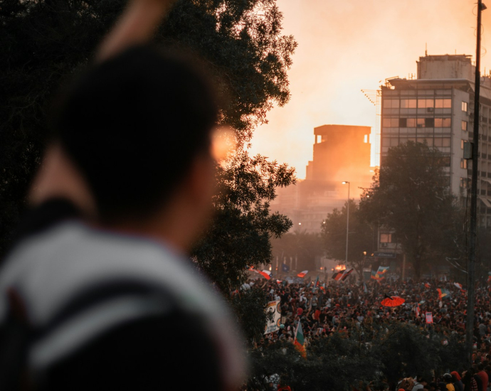 a crowd of people standing on a street next to tall buildings