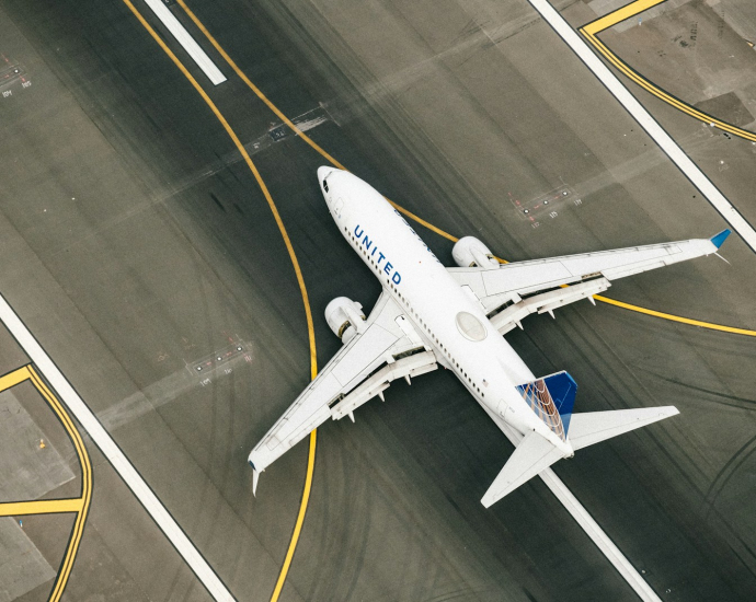 white and blue airplane on airport during daytime