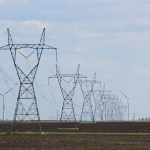 transmission towers and wind turbines on the field