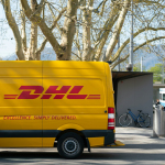 man standing in front of DHL truck door