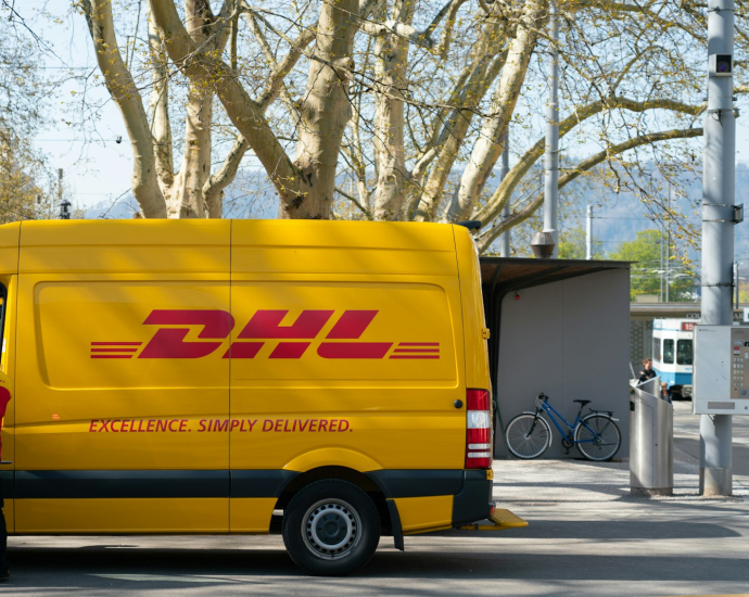 man standing in front of DHL truck door