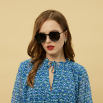 Woman wears sunglasses and a blue patterned dress.