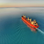 red and white cargo ship at middle of ocean