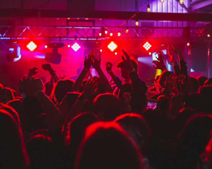 people standing on stage with lights turned on during nighttime